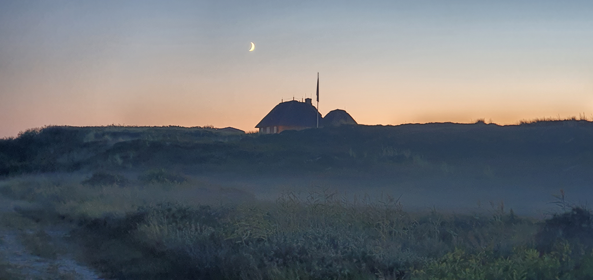 Haus auf Deich mit Mond